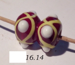 doppelte rot-braune Perle mit je vier weißen abstehenden Punkten in gelber Achterschleife