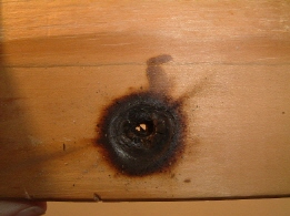 Glasperle auf Holzplatte mit Brandspuren