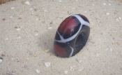 schwarze Perle mit 5 roten Augen udn weißer Achterschleife