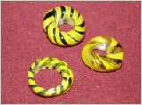 Spiralperlen, grün-gelb; bei allen drei Perlen ist es eine durchgehende gelbe Fadenauflage