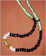 Glasperlenkette, eine Perle aus Berinstein, sehr viele schware und weiße Perlen