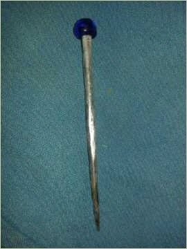 eine Tracht- oder Haarnadeln, etwa 10cm lang, Spitz zu laufende, mit einer blauen aufgeschmolzenen Glaskugel als Kopf