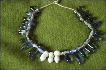 Bommelperlen, auch vasenförmige Perlen genannt, blau und weiß, wie lange Glastrope an einer Öse, daran ein Zipfel